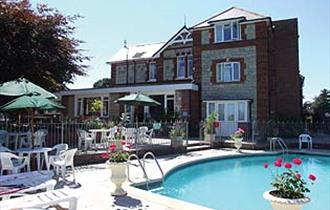 Outside swimming pool with dining chairs at Eastmount Hall Hotel, Shanklin, Isle of Wight