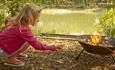 Toasting marshmallows on fire pit by lake at The Lakes Rookley, Isle of Wight, Self Catering