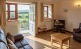 Lounge area with door open to the garden with views of rolling hills, Nettlecombe Farm, self catering, Isle of Wight