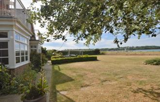 Side view of house with garden leading to the watersedge  - self-catering, Isle of Wight, HB Holiday Lettings Side view of house with garden leading to the watersedge  - self-catering, Isle of Wight, HB Holiday Lettings