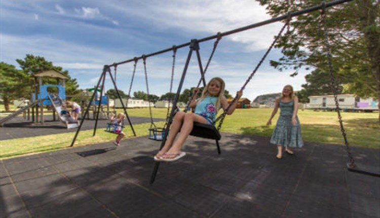 Child on the swing at the playground at Sandhills Holiday Park, Bembridge, Isle of Wight