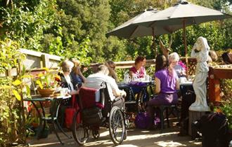 Group of people sitting outside in the sun, Writing workshop at The Grange, Shanklin, Isle of Wight, wellness course