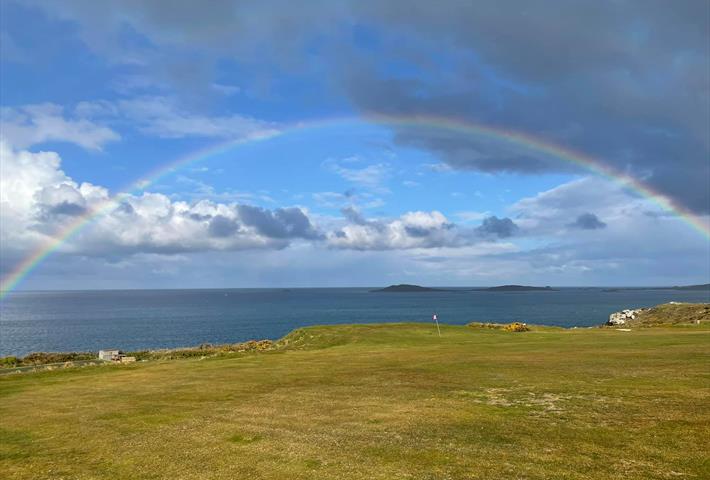 Rainbow over the sea from golf course
