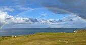 Rainbow over the sea from golf course
