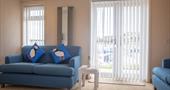 Blue sofa in a lounge in front of a window and patio doors
