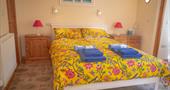 A yellow kingsize bed with folded towels on