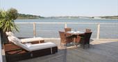 Outside view with table, chairs and sun loungers overlooking the Hayle Estuary.