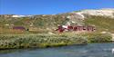 Blue river flows past Krossbu tourist cabin in the summer.