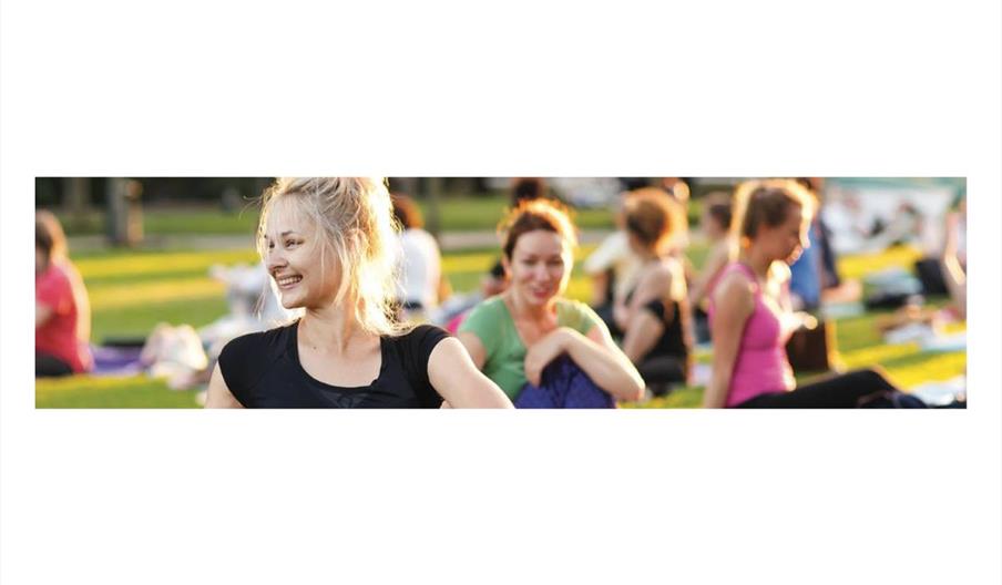 ladies sat outside in the sun doing yoga