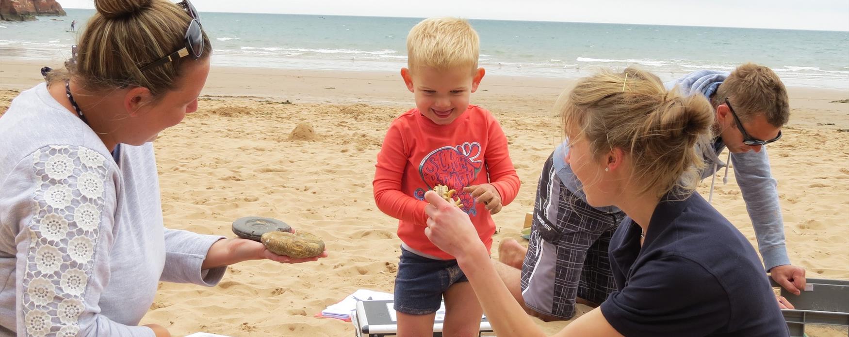 Jurassic Coast Ambassador Emily Cowper-Coles with a young fossil fan at Sandy Bay.