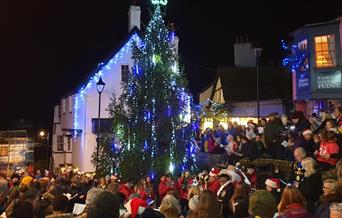 People singing carols around a Christmas tree in Lyme Regis