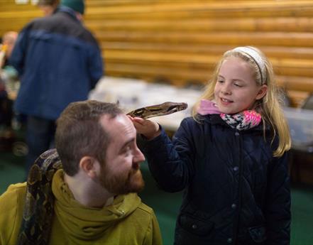 Child getting to experience holding a snake at Animal Magic event