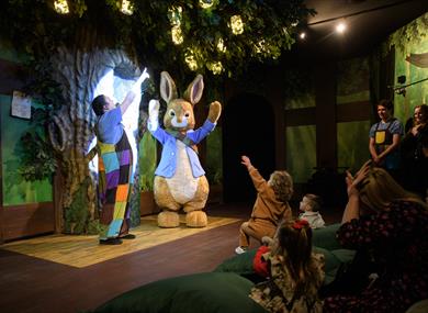 Peter Rabbit performs on stage for delighted children.