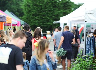 Visitors to the market browse the stalls carrying their delicious finds.
