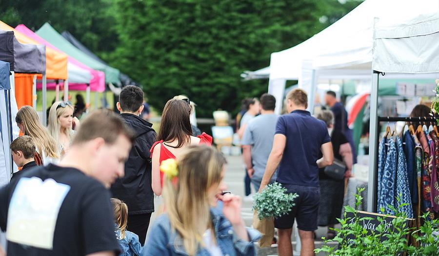 Visitors to the market browse the stalls carrying their delicious finds.