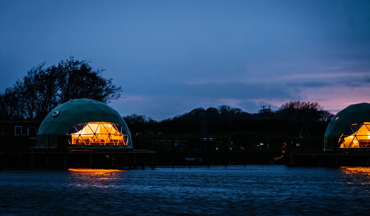 Nighttime view of the pods from across the river.