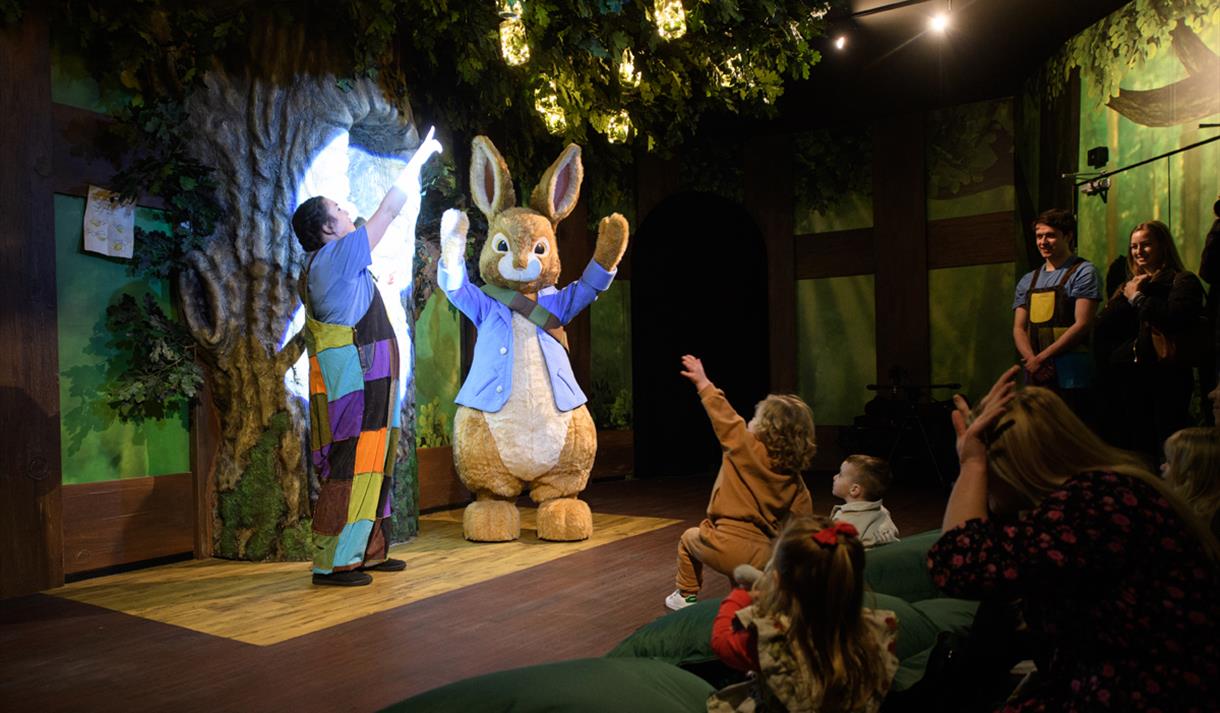 Peter Rabbit performs on stage for delighted children.