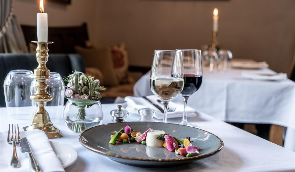 Table set for dinner at Coach and Horses with a candle and a glass of wine.