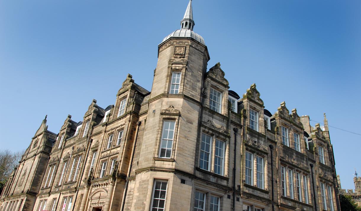 The Grade Two listed Storey building made of sand coloured stone with tall Georgian windows, and a tower with spire.