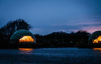 Nighttime view of the pods from across the river.