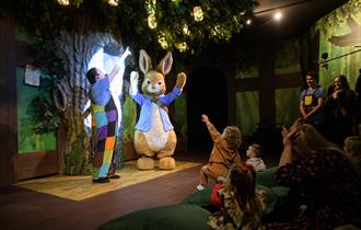 Peter Rabbit performs on stage for delighted children.