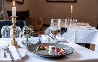 Table set for dinner at Coach and Horses with a candle and a glass of wine.