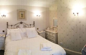 A double room with a comfortable double bed with white linen.