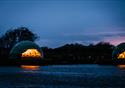 Nighttime view of the pods from across the river.