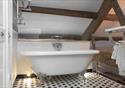 Stylish beamed bathroom with stand alone bath tub