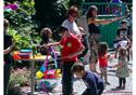 Children trying out circus skills outside in the bright sunshine.