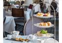 Afternoon tea serving on a tiered display of scones, sandwiches and assorted cakes.