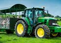 The green farm tractor is taking visitors on a tour of the farm