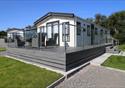 Caravan with grey decking and glass fence