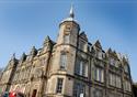 The Grade Two listed Storey building made of sand coloured stone with tall Georgian windows, and a tower with spire.