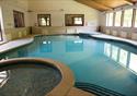 A swimming pool with plenty of natural light from the many windows.