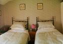 A twin bedroom with identical beds awaiting guests of The Ridges.