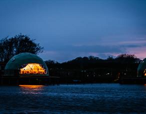 Nighttime view of the pods from across the river.