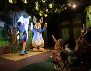 Peter Rabbit performs on stage for delighted children.