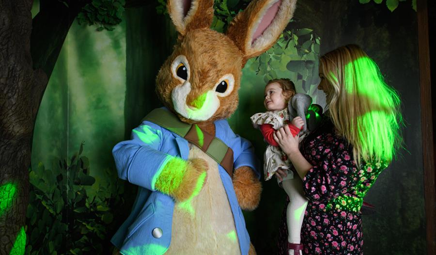 A child and her mother is delighted to meet Peter Rabbit.