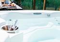 A clean and spacious hot tub with an area to hold and cool drinks to enjoy.