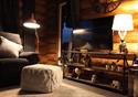 A cozy cabin living area in the evening, lit with lamps.