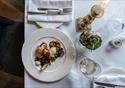 Picture of meal from menu at Coach and Horses.  An shot from above the table looking down at a chicken dish on white crockery with white table linen.