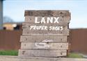 A wooden LANX proper shoes sign.