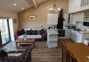 Roosters Rest.  A view of the lounge area in the cottage with lots of natural light.  Comfortable sofas, wooden floor, dining area and kitchen all fea