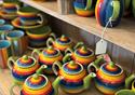 Rainbow teapots, cups and saucers.