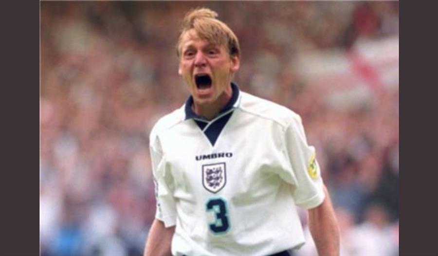 A photograph of Stuart celebrating on the pitch in an England national kit.