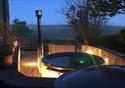 Outside picture of the hot tub at sunset, looking across at the picturesque view.