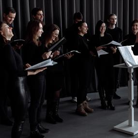 Group of people in black outfits about to sing