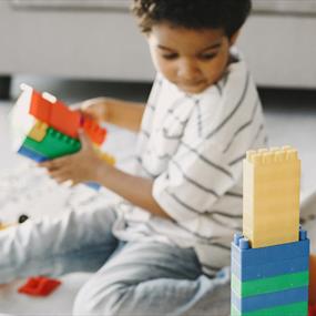 A child playing with colourful plastic building bricks