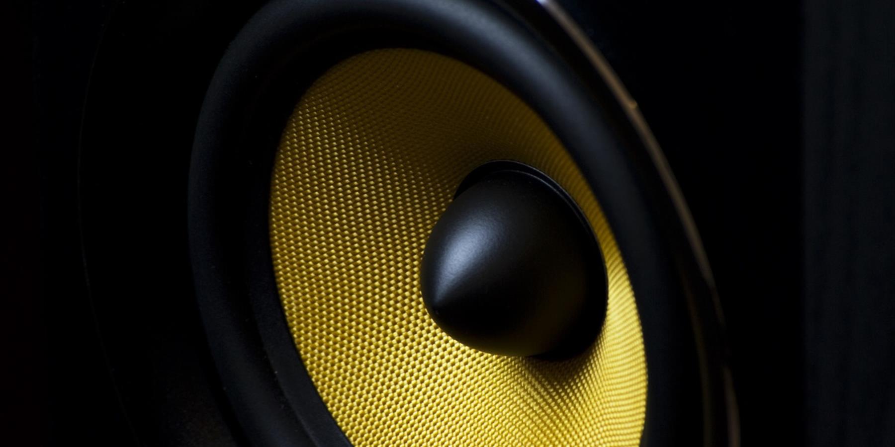 Zoomed in shot of a black speaker with bright yellow mesh